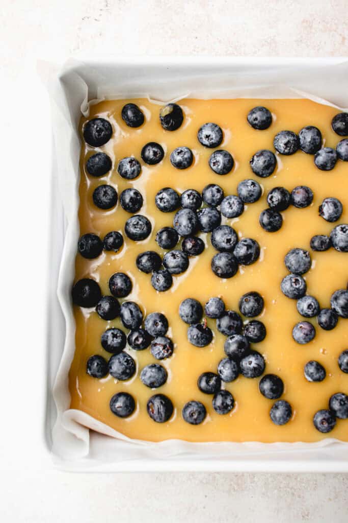 Fresh blueberries sprinkled on top of the lemon curd, layered on top the crust in a square baking pan.