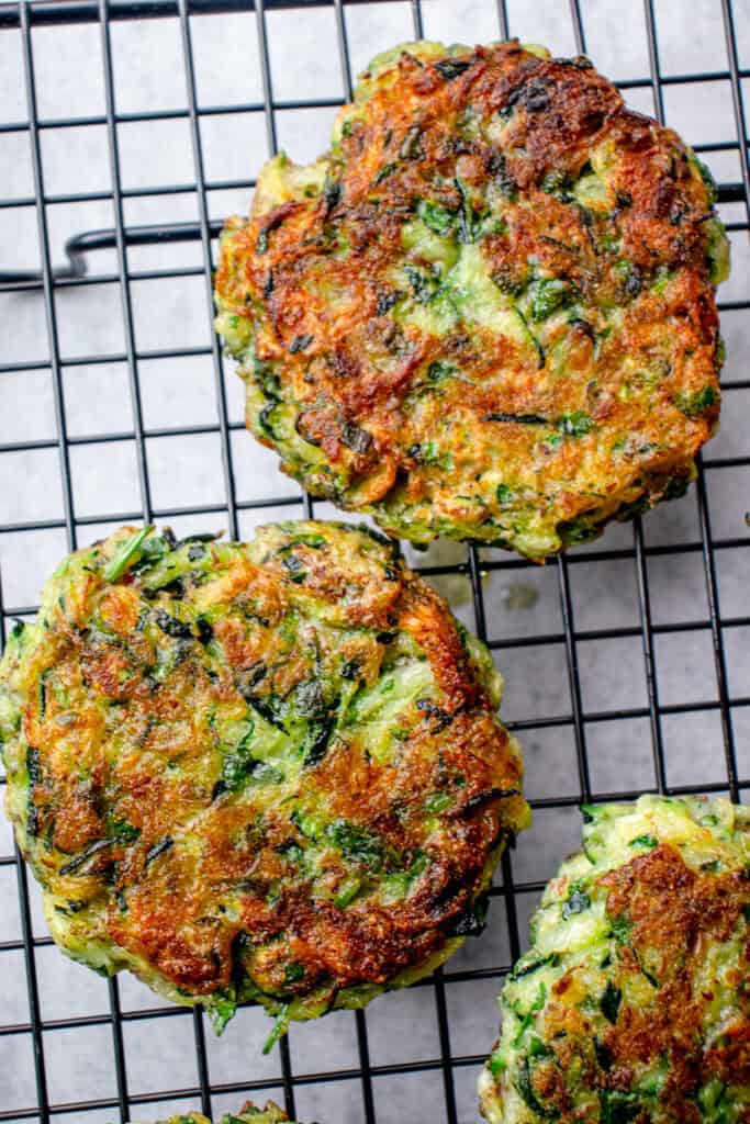 Three Gluten Free Zucchini Fritters on a wire cooling rack.