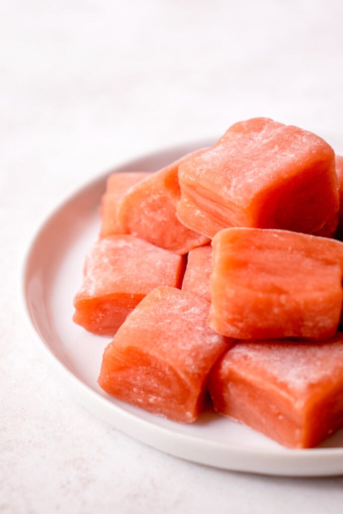 A white plate with Watermelon Mochi squares.