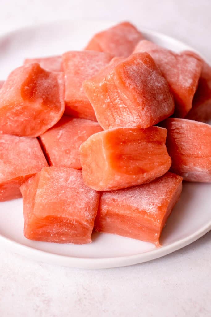A white plate with Watermelon Mochi squares.