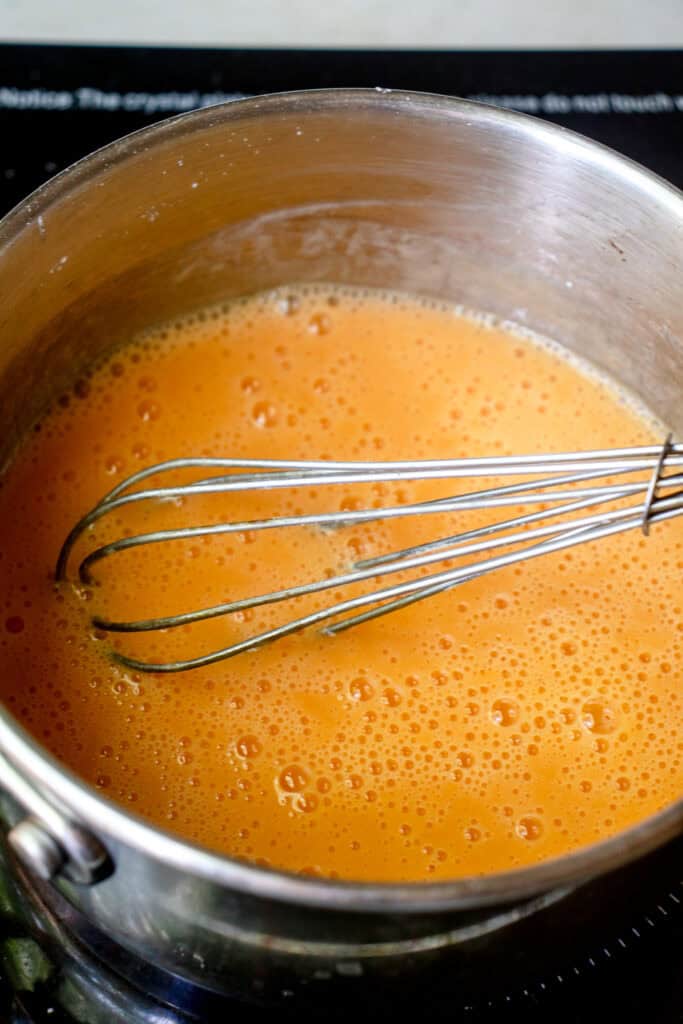 Whisking together cantaloupe juice, arrowroot starch, maple sugar, and pinch of salt in a saucepan.