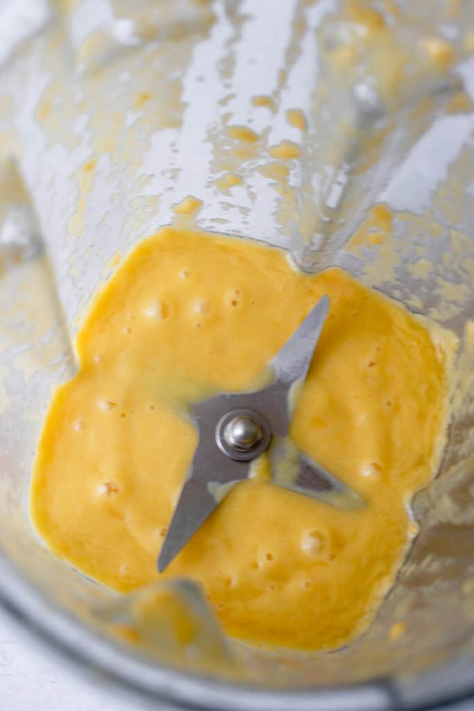 Mango and coconut milk purée in a blender.