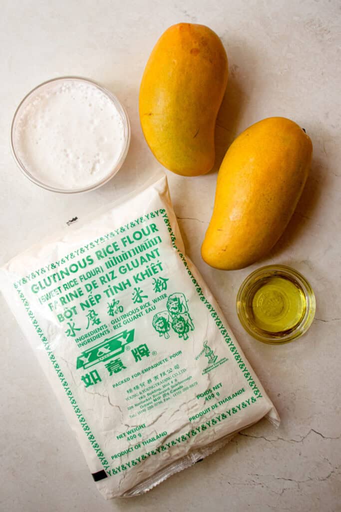Ingredients to make this Mango Mocho recipe. Clockwise from top: two ripe mangoes, avocado oil, glutinous rice flour, and coconut milk.