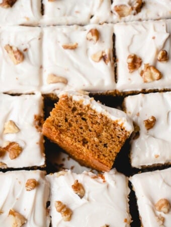 Overhead close up of squares of frosted cake with one piece on its side.